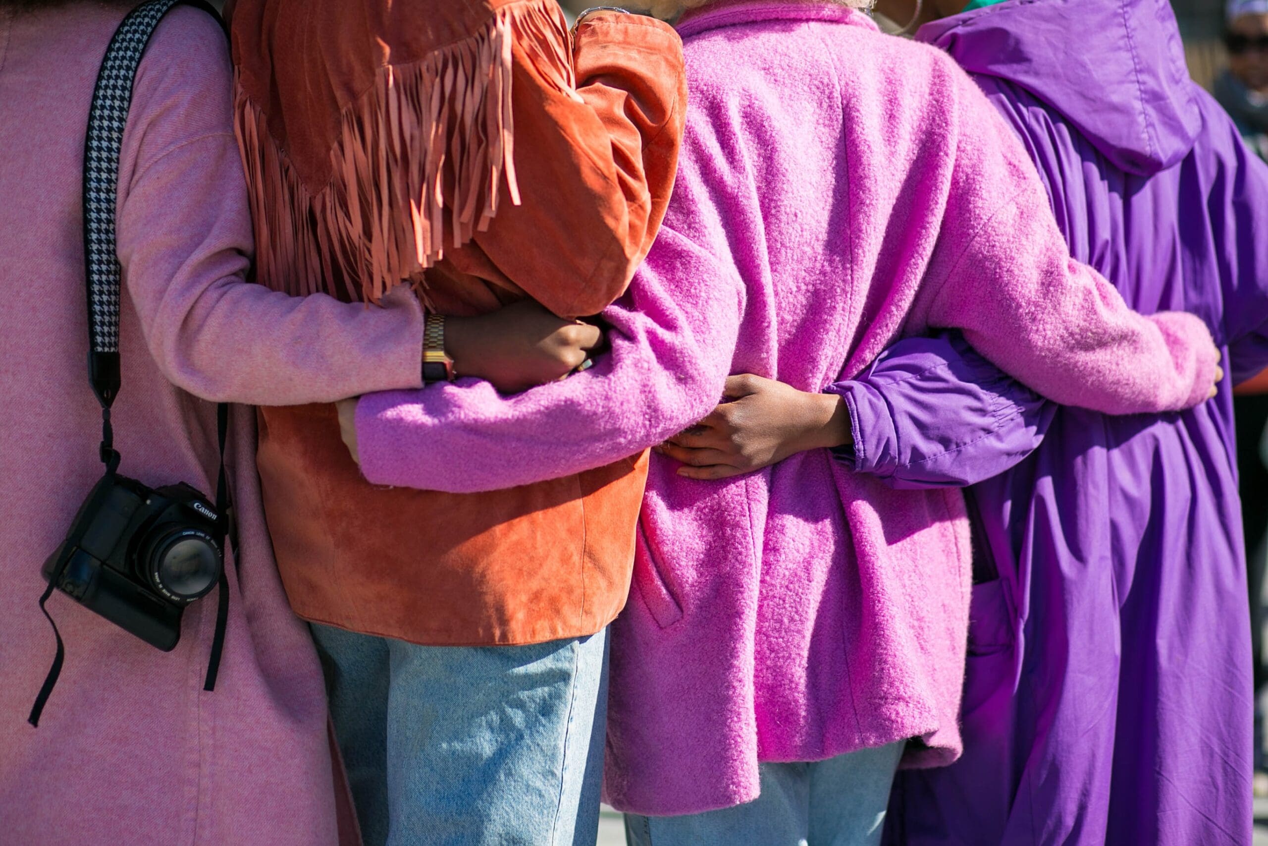 Four people with their arms around each other