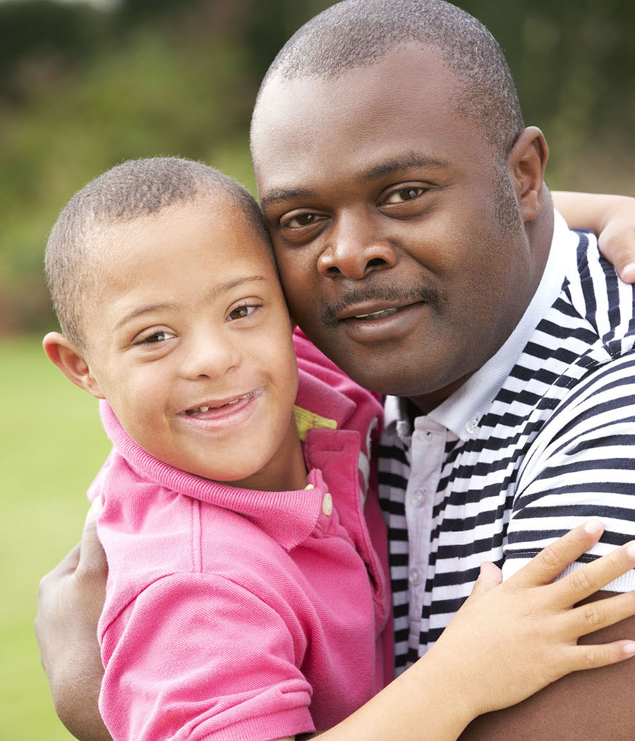 A father embraces his son who has down syndrome