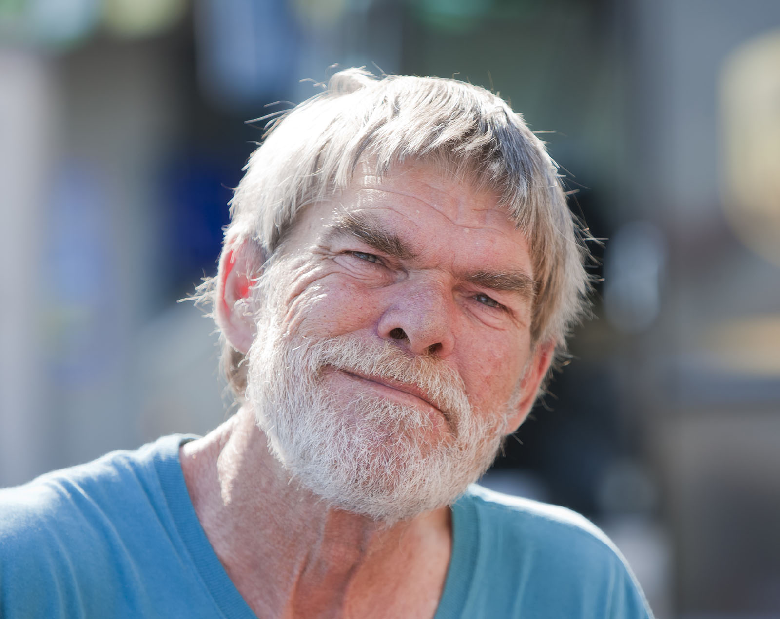 A senior man outside in a blue shirt smiling