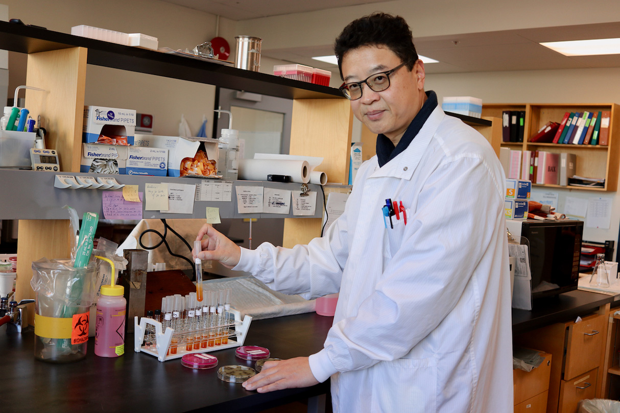 A man holds a test tube in the BCCDC laboratory
