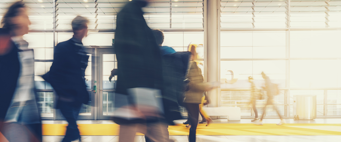 A busy public transportation walkway with blurred people walking through the photo