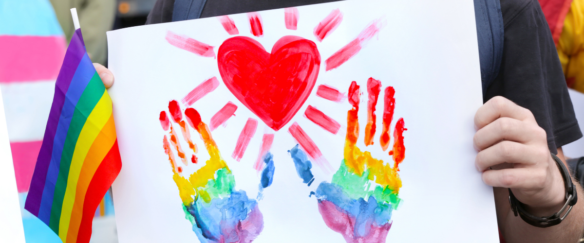 a painting of hands and a heart in rainbow colours