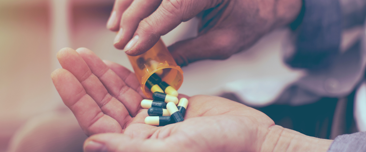 antibiotics being poured out into a hand from a pill case