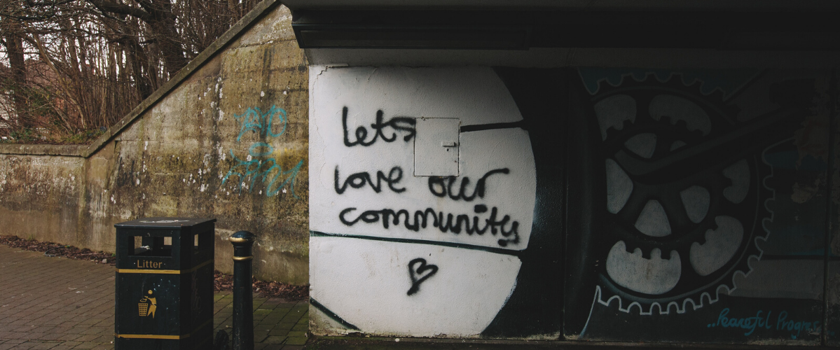 graffiti on a wall that reads "lets love our community"