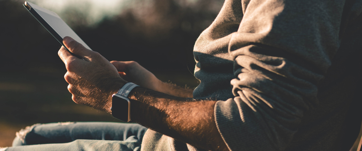 Hands holding a tablet outside