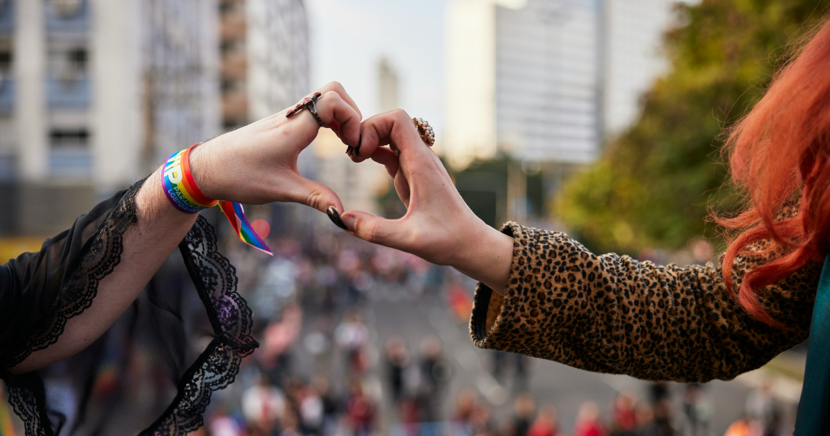 Two people put their hands together to form the shape of a heart