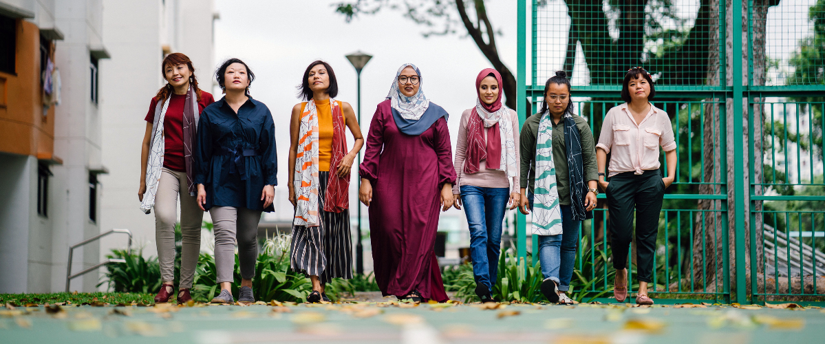 Seven diverse women standing outside in a line