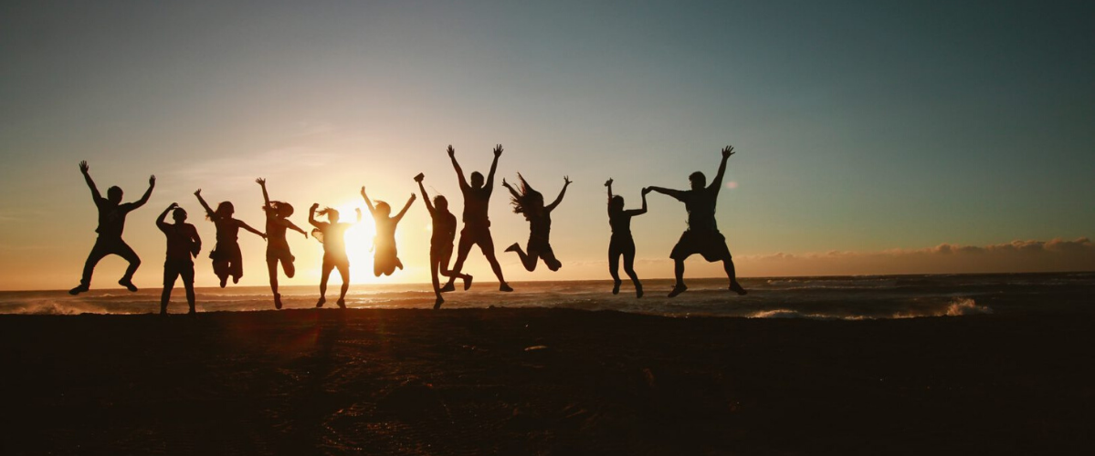 a group of people along a horizon during a sunset jump