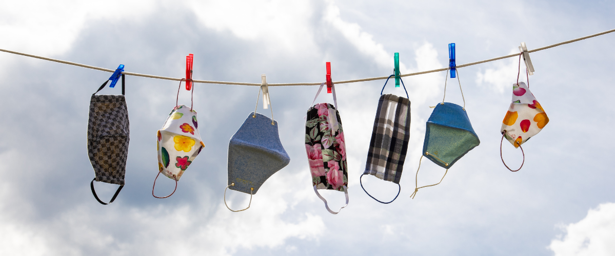 face masks hang drying outside on a clothing line