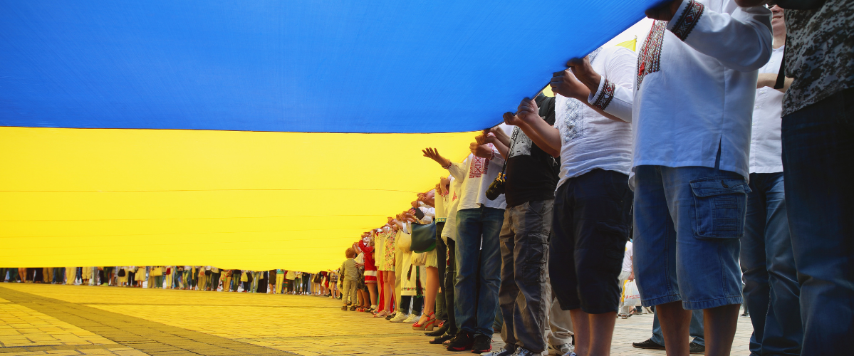 A group of people hold up a Ukrainian flag