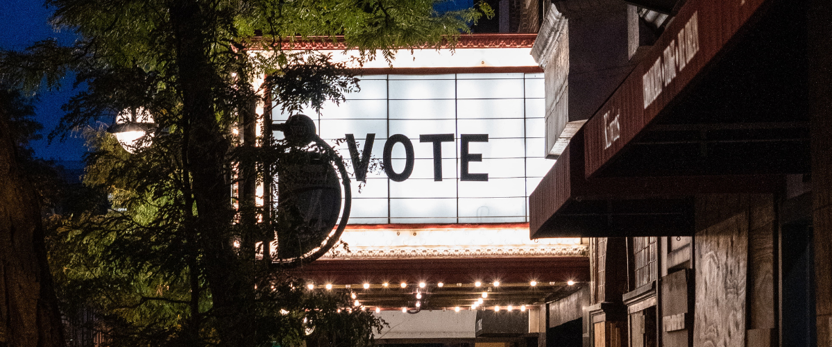 a sign light up with the word vote